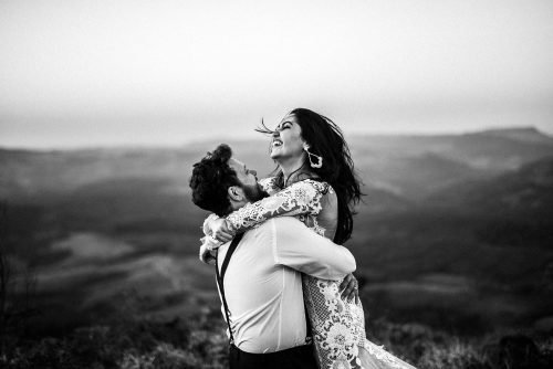 Man holding his woman in field over with mountain background